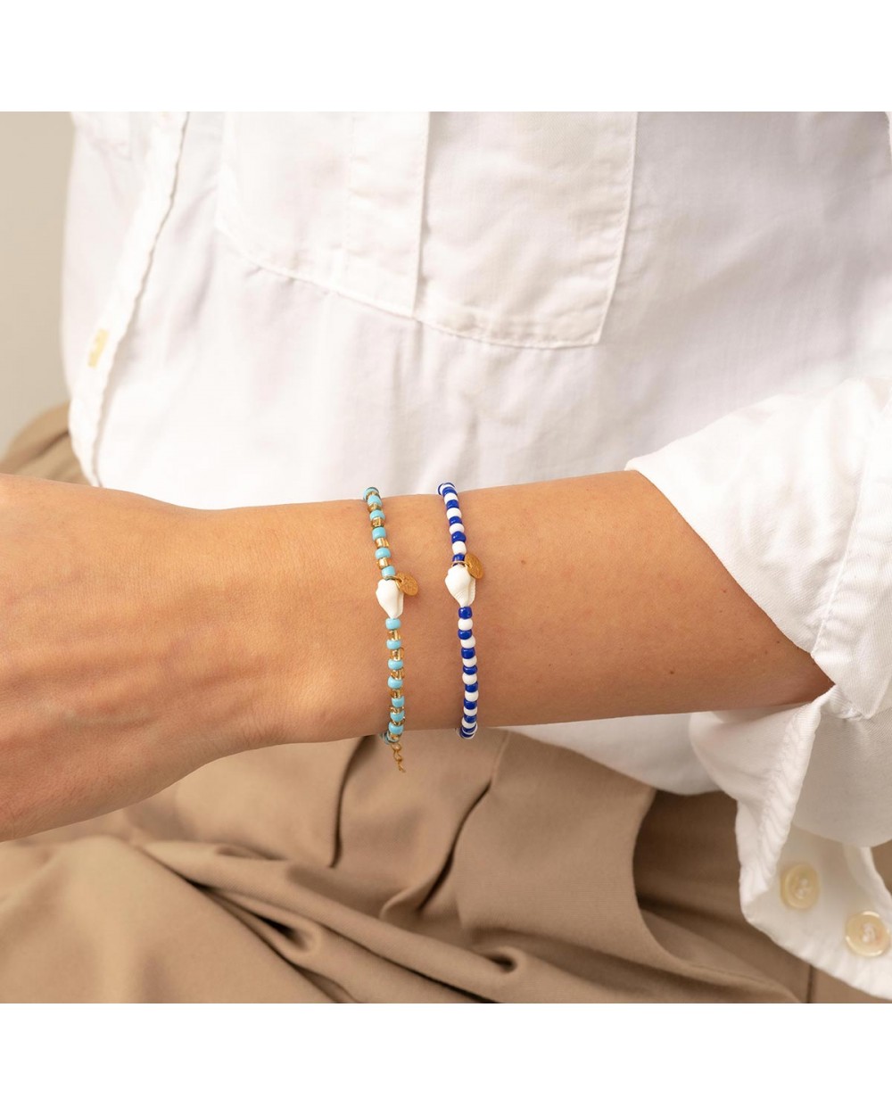 Χειροποίητο βραχιόλι της Excite Fashion Jewellery, κοχυλάκι, λευκές και μπλέ χάντρες, κρεμαστό μοτίφ, από επιχρυσωμένο ανοξείδωτο ατσάλι. B-1761-07 Κοσμήματα Χειροποίητο βραχιόλι της Excite Fashion Jewellery, κοχυλάκι, λευκές και μπλέ χάντρες, κρεμαστό μοτίφ, από επιχρυσωμένο ανοξείδωτο ατσάλι. B-1761-07 Κοσμήματα