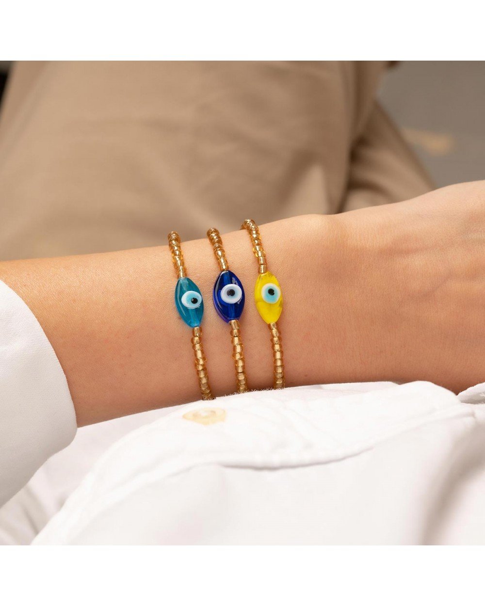 Χειροποίητο  βραχιόλι της Excite Fashion Jewellery, οβάλ γυάλινο γαλάζιο μάτι και χρυσές χάντρες, από επιχρυσωμένο ανοξείδωτο ατσάλι. B-1766-07 Κοσμήματα