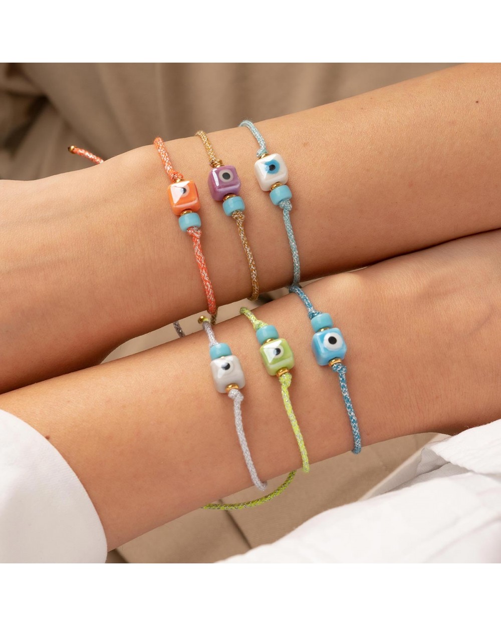Χειροποίητο βραχιόλι της Excite Fashion Jewellery, δίχρωμο κορδόνι, λευκό ματάκι κύβος, τιρκουάζ χάντρα, και χρυσές μπίλιες. B-1774-17 Κοσμήματα